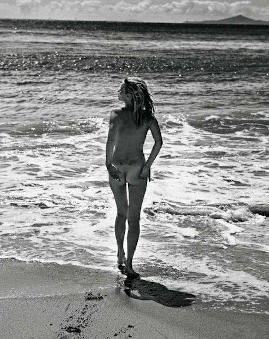 следы на песке. тонконогая нагая девушка идет по песку в море, прикольное фото с эротикой
