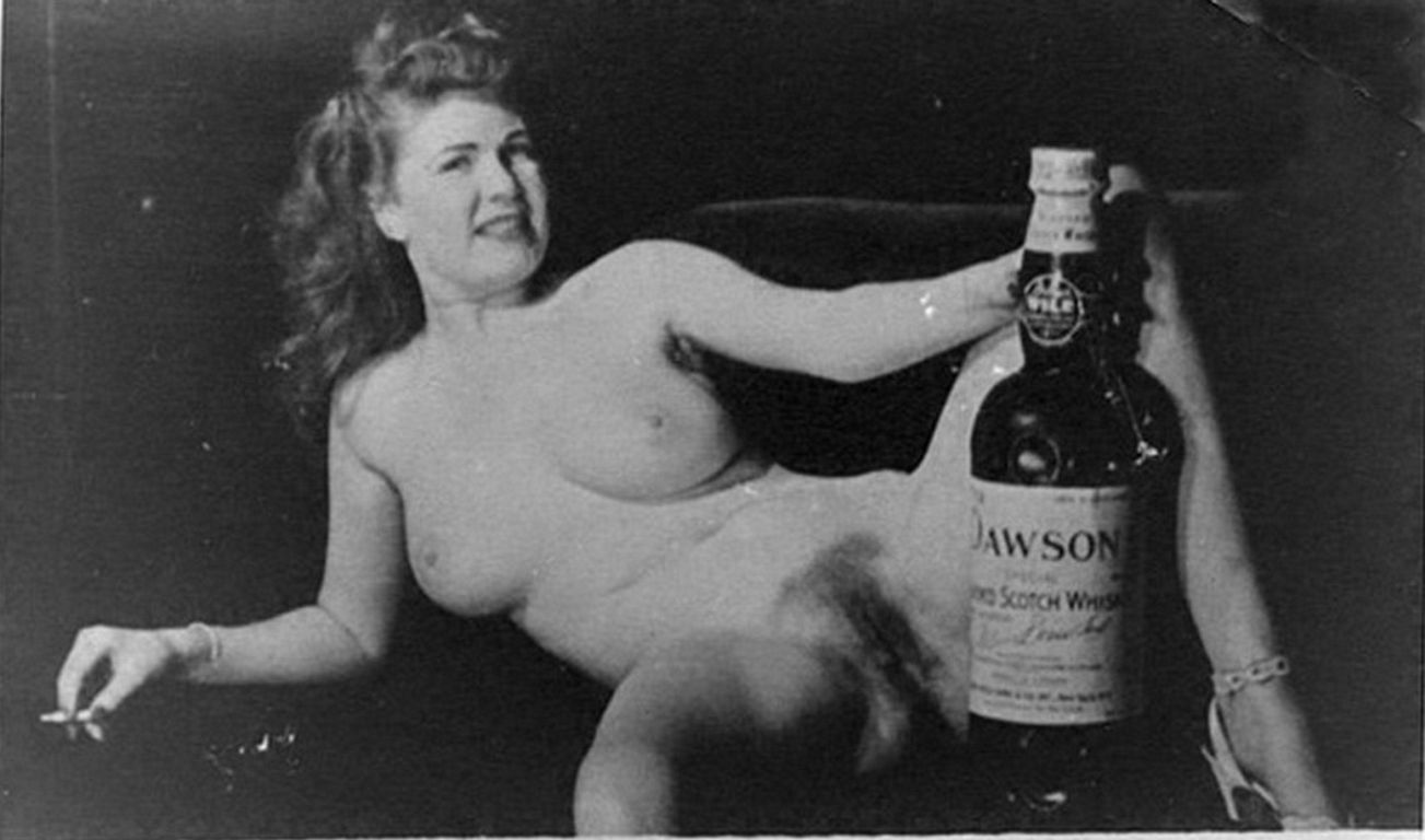 Ретро обои для рабочего стола. голая тетка с сигаретой раздвинув волосатые ноги держит между ними большую бутылку виски, обои девушки ретро фото