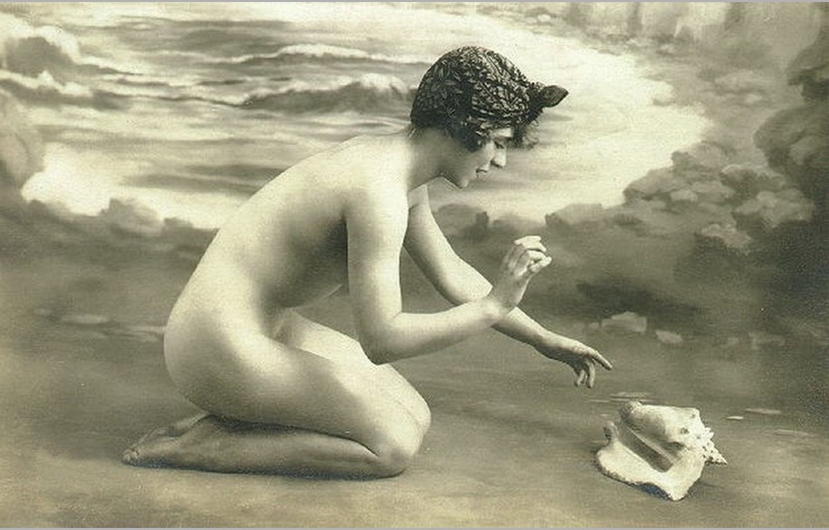обнаженная девушка на берегу играет с раковиной, обои девушки ретро фото