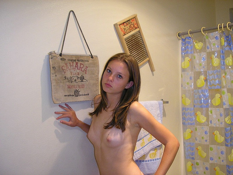 домашнее эротическое фото девушки с маленькой грудью стоящей у стены, голые сиськи фото