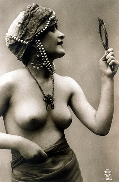 молодая женщина с маленькой грудью смотрится в зеркальце, ретро фото эротика
