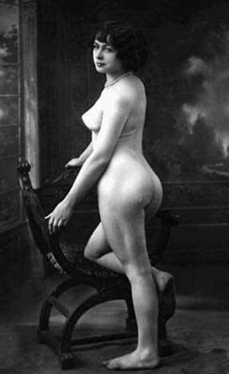 попа голой красотки прошлого века стоящей в полный рост у деревянного кресла, фото женской большой попы
