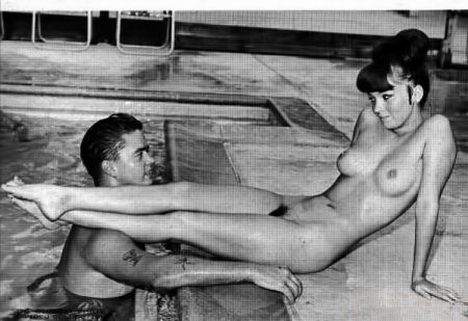 полностью голая девушка положила ноги на плечо своего бойфренда сидя на краю бассейна. ретро фото женской попы