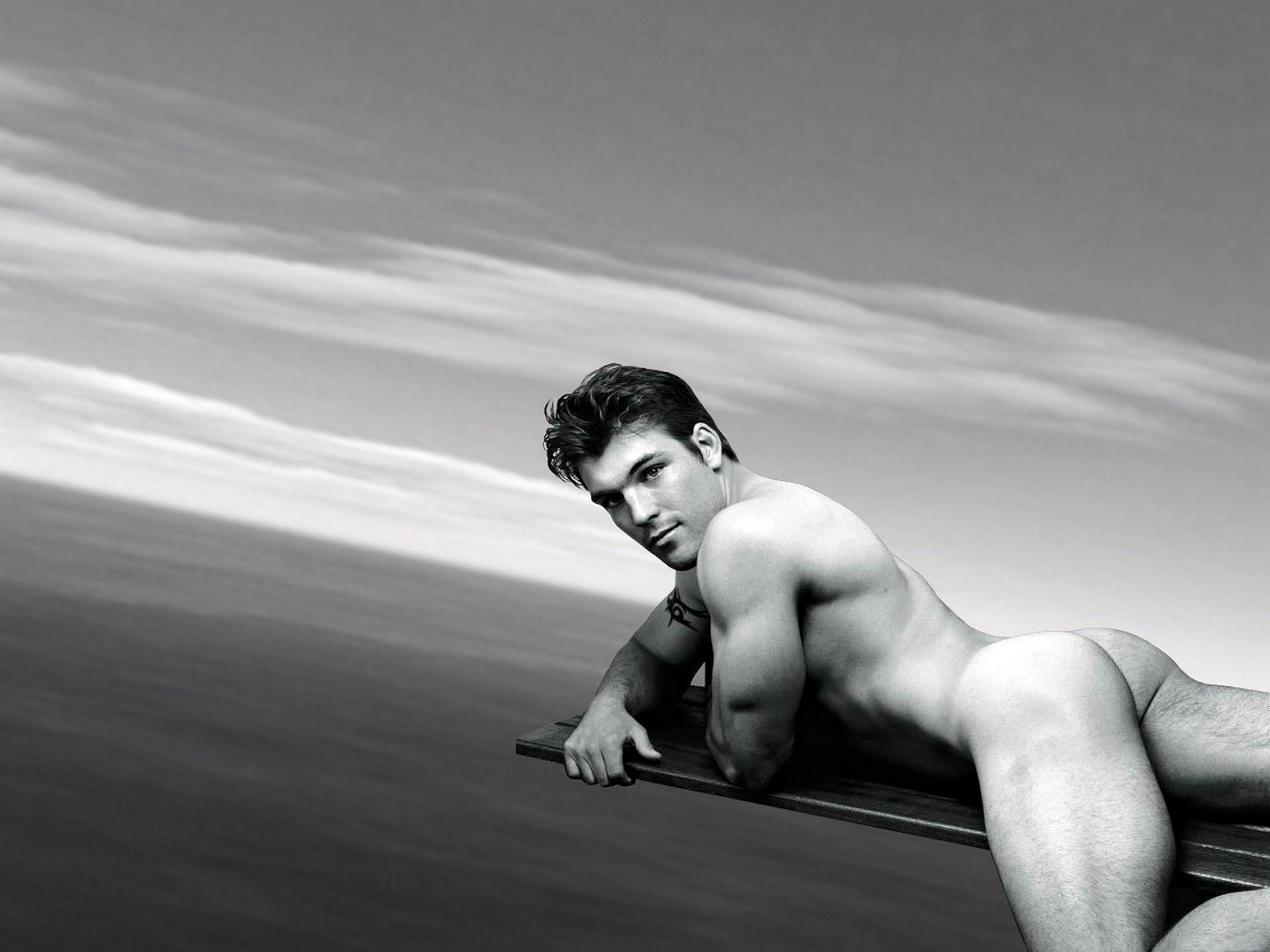 голый мужчина лежит животом на доске над морской гладью, фото красивого мужчины