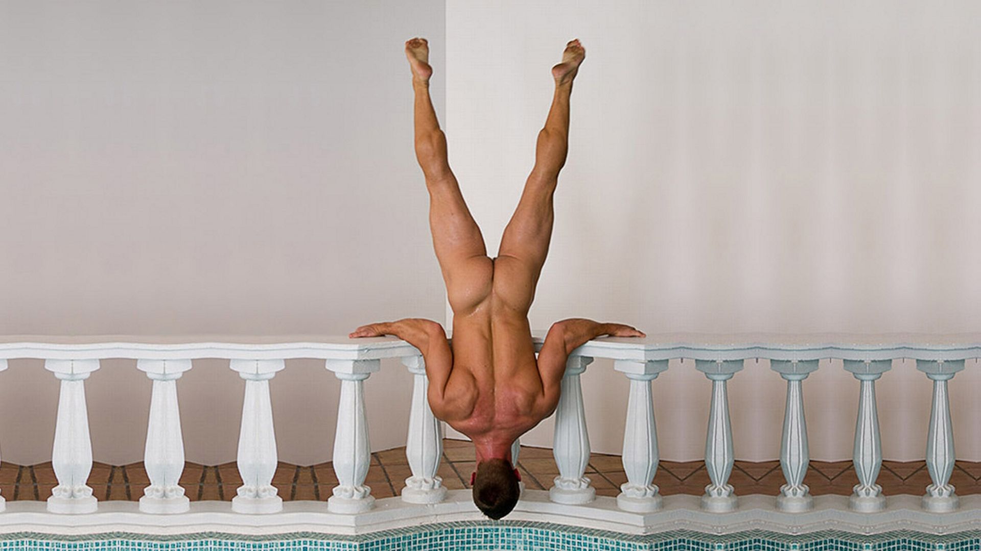 голый мужчина делает стойку вверх ногами на бассейном, фото красивого мужчины