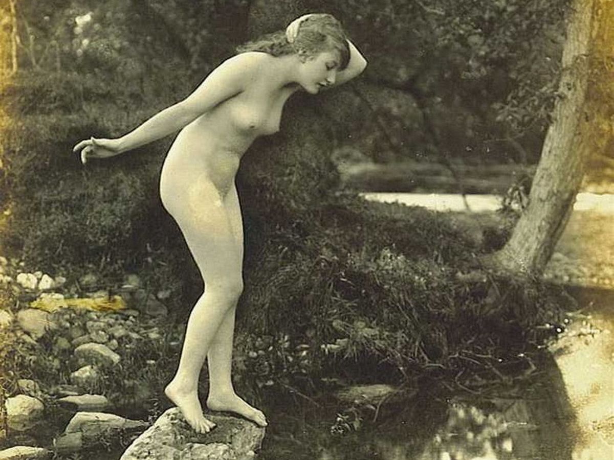 обнаженная девушка позирует стоя на камне у озера, обои девушки ретро фото