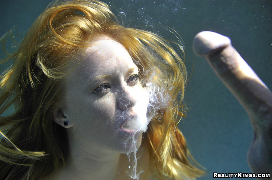 конопатое лицо рыжей девушки под водой с расплывающейся из ее рта спермой после подводного минета с огромным пенисом, член в сперме порно фото