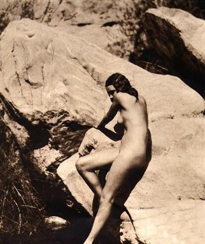 Обнаженная женщина прижалась к скале, фото мастурбации