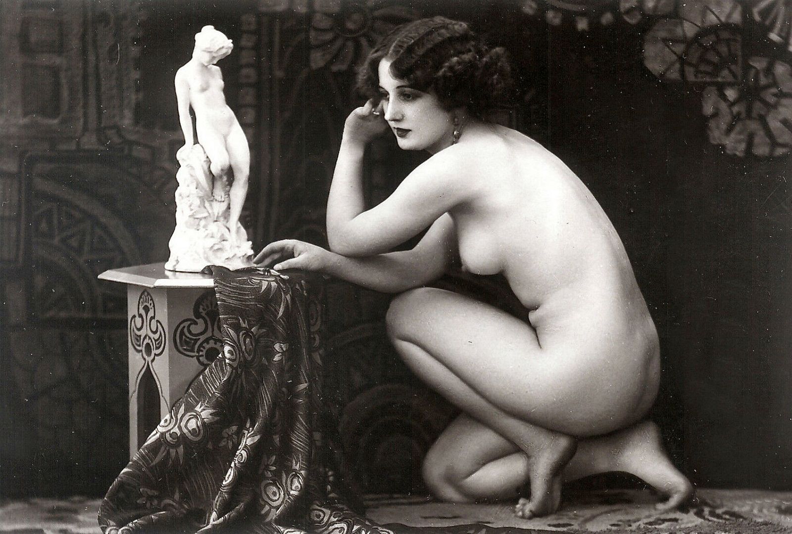 голая красотка с большой попой сидит на корточках возле небольшой скульптуры, фото женской большой попы